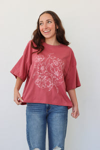 girl wearing pink t-shirt with white floral graphic