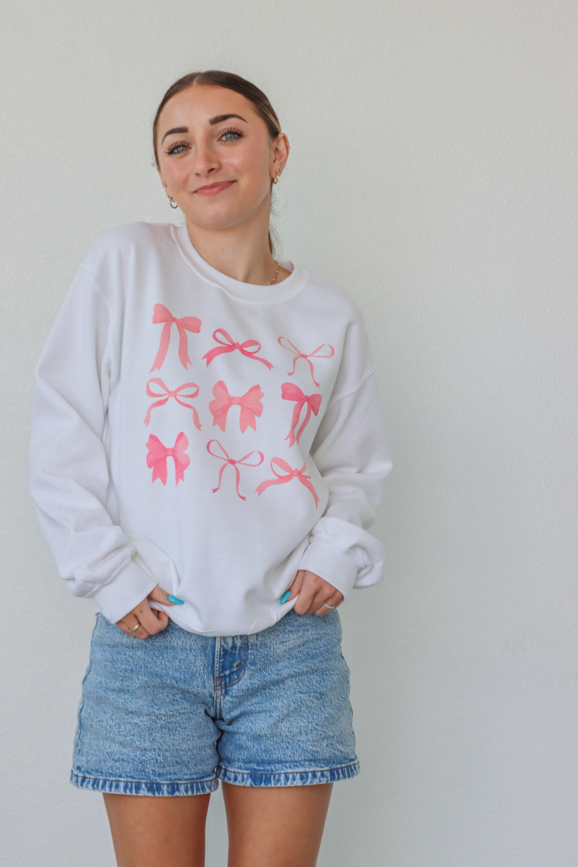 girl wearing white crewneck with pink bow screenprinted pattern