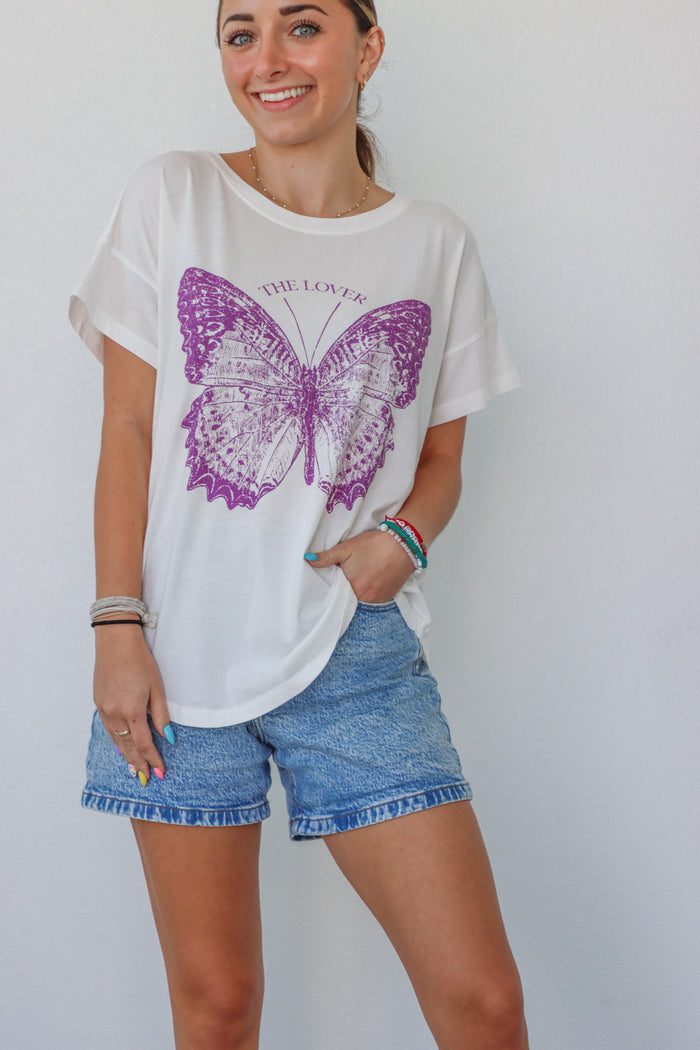 girl wearing white t-shirt with purple butterfly graphic
