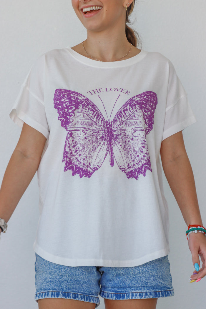 girl wearing white t-shirt with purple butterfly graphic