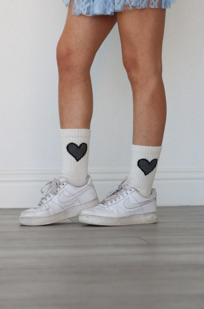 girl wearing white socks with black heart
