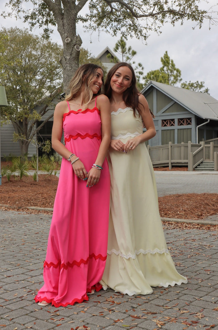 two girls wearing dresses in different colors - one pink, and one yellow