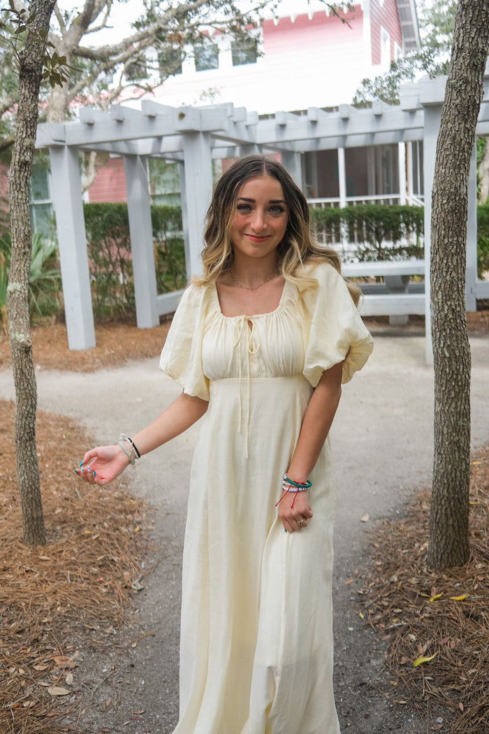 girl wearing cream long dress with puff sleeves