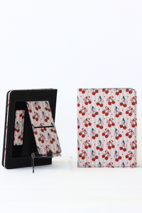 Cherry-patterned kindle case with stand feature on a white background