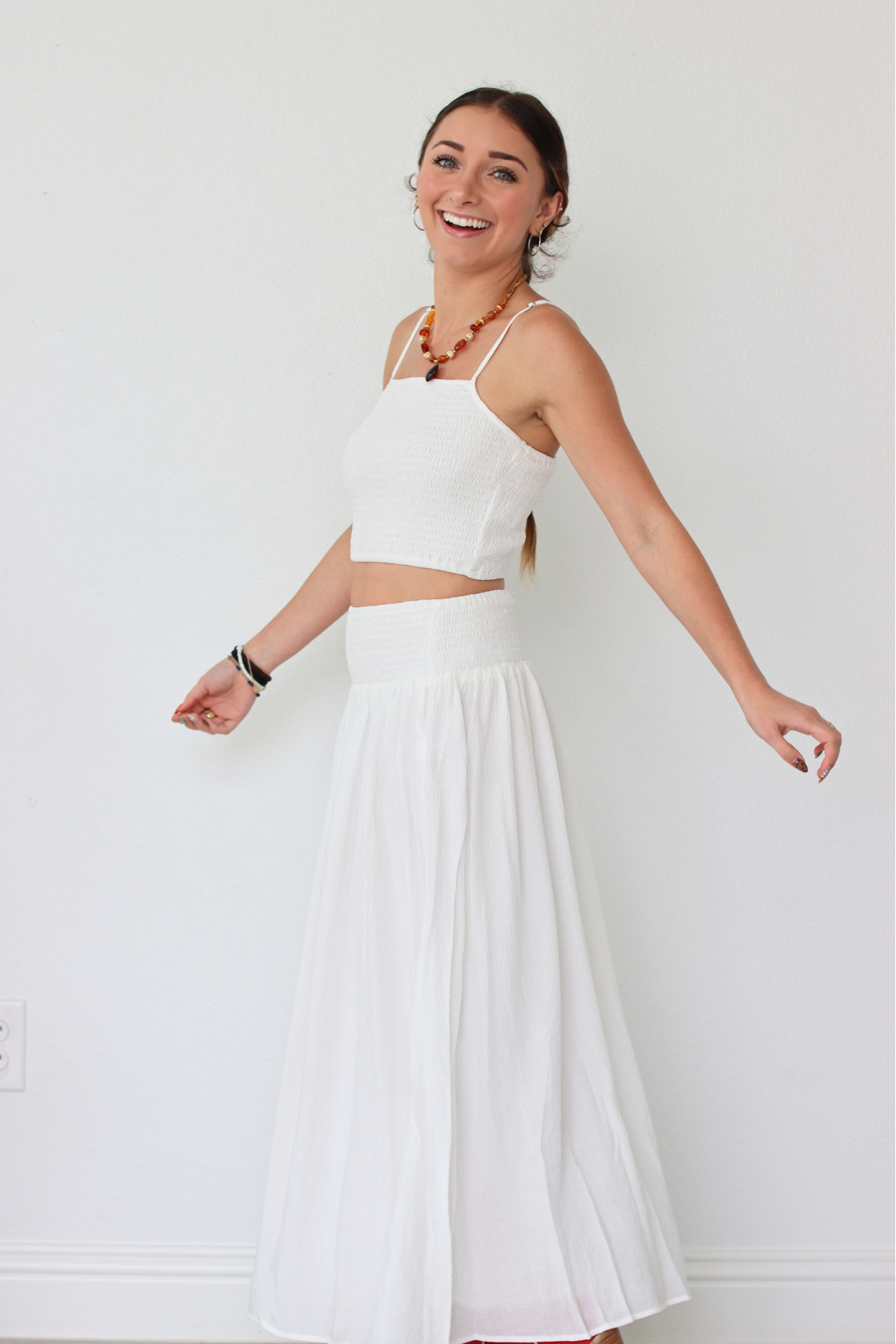 Woman wearing a white set against a plain background