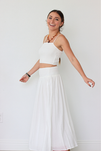 Woman wearing a white set against a plain background