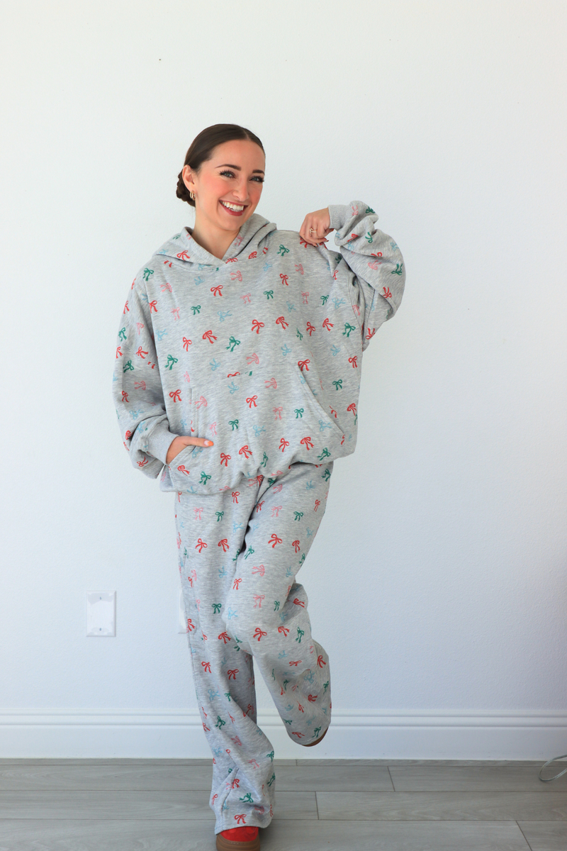 Person wearing a gray onesie with colorful patterns against a white wall.