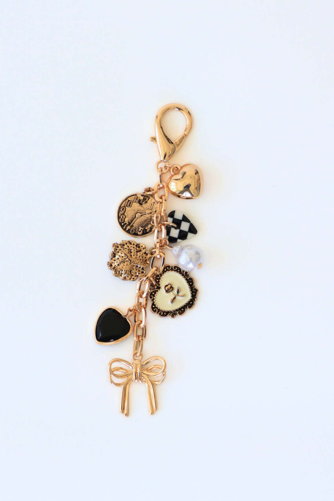 Gold charm keychain with various charms on a white background
