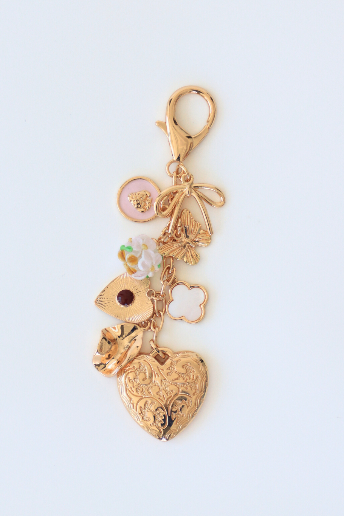 Gold charm with heart design on a light blue background