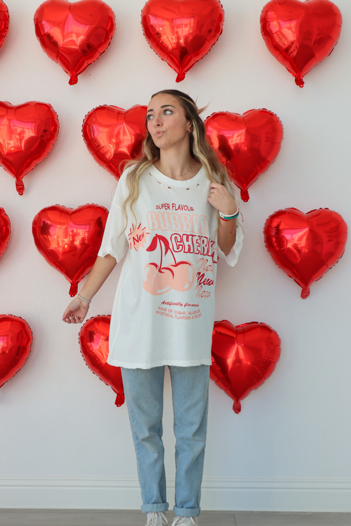 girl wearing white oversized graphic tee, "bubble cherry" graphic 