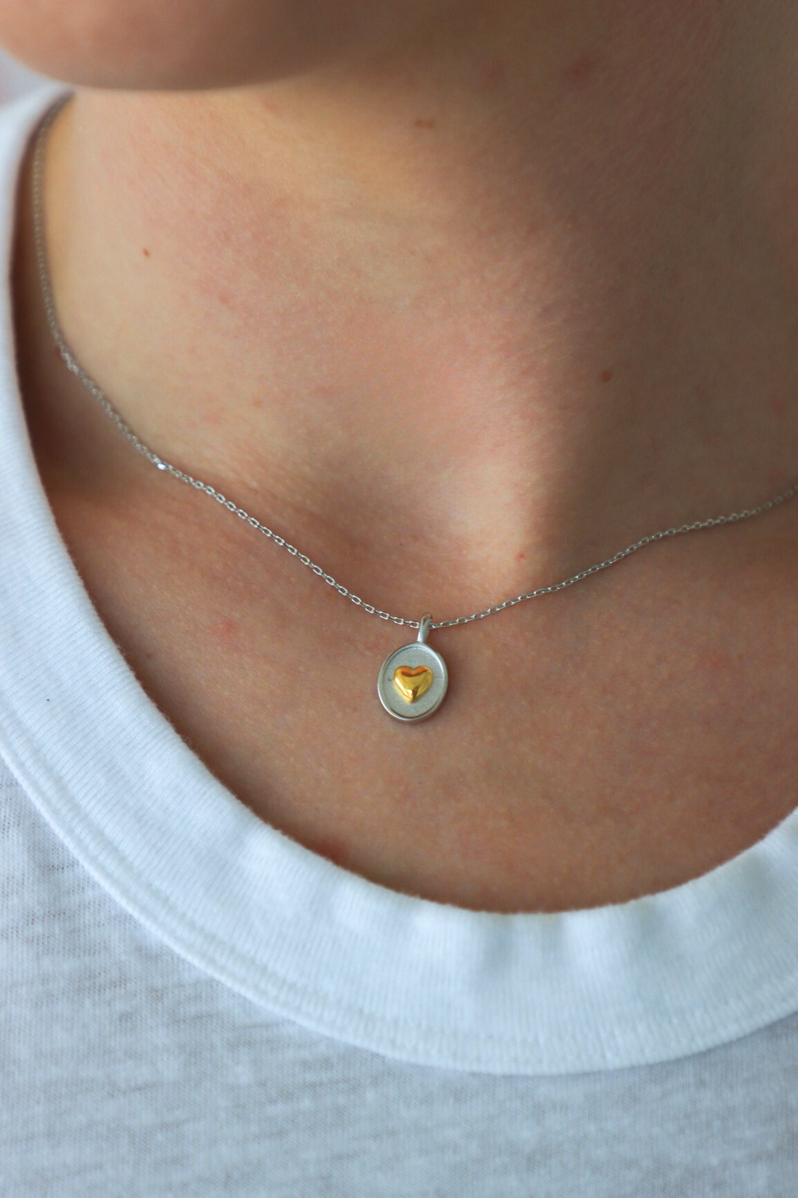 Necklace with a yellow gemstone pendant worn by a person