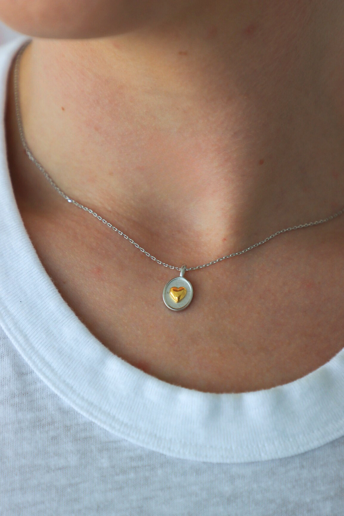 Necklace with a yellow gemstone pendant worn by a person