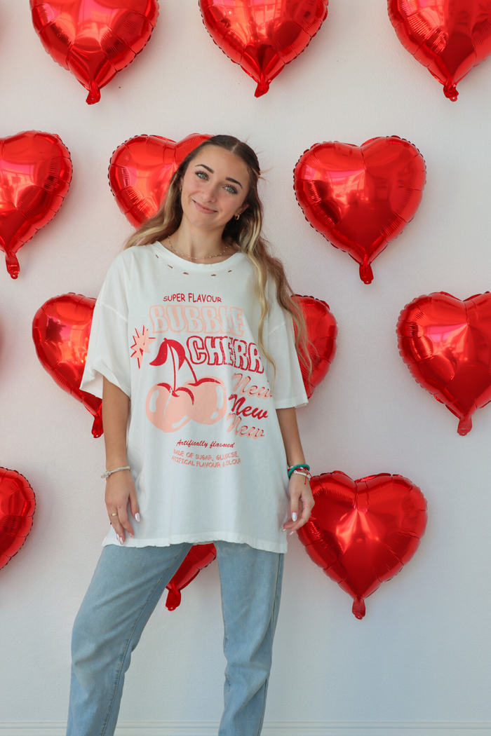 girl wearing white oversized graphic tee, "bubble cherry" graphic 