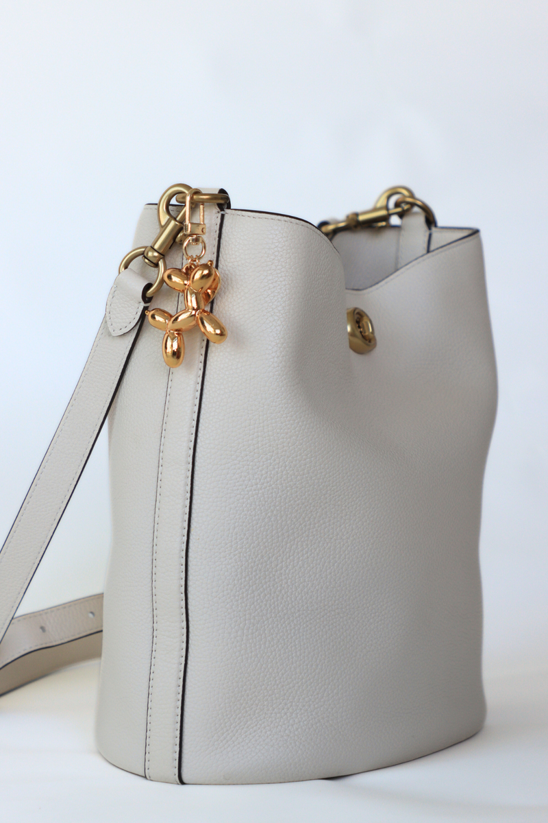 Light gray handbag with gold accents on a white background