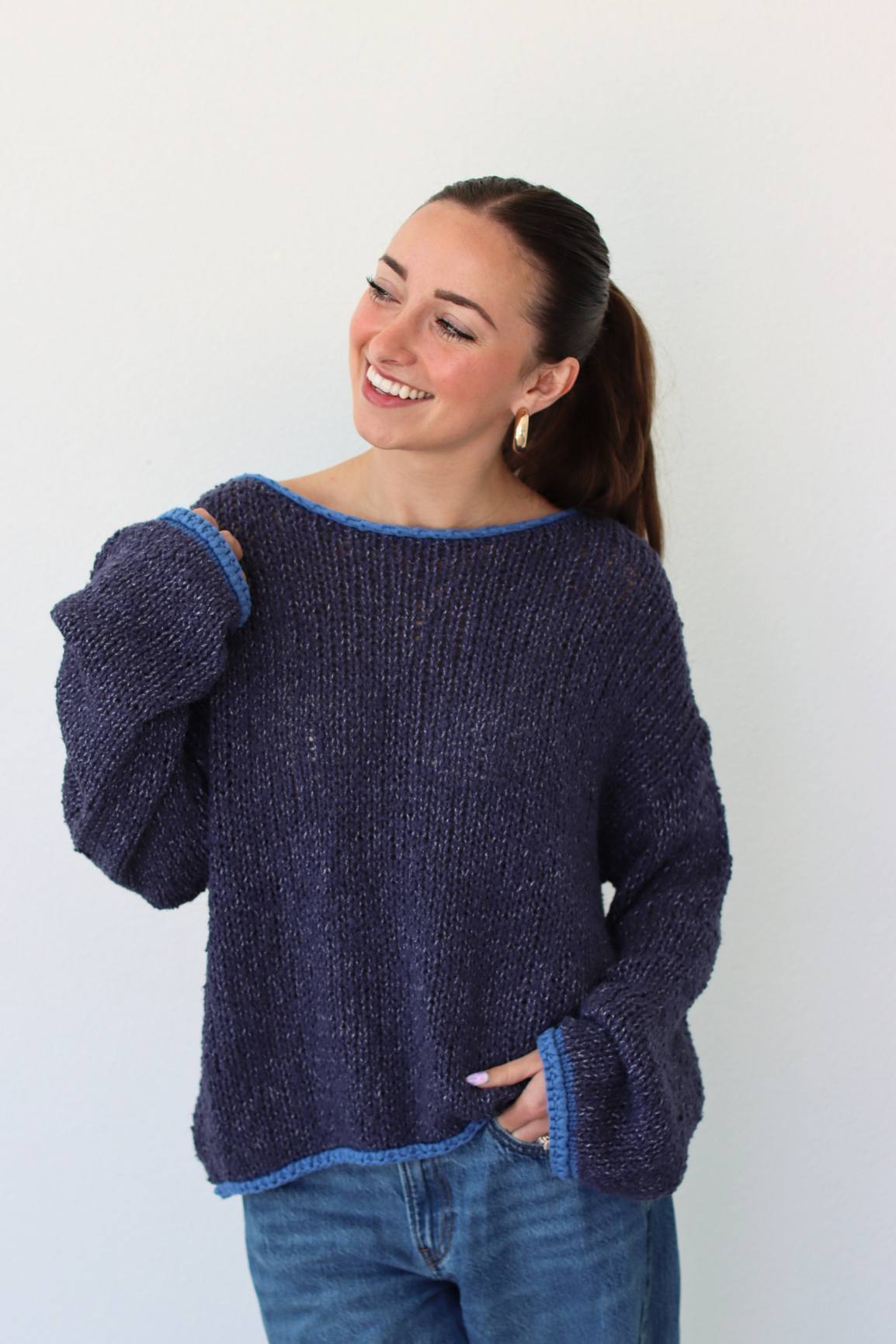 Woman wearing a dark blue sweater against a white background