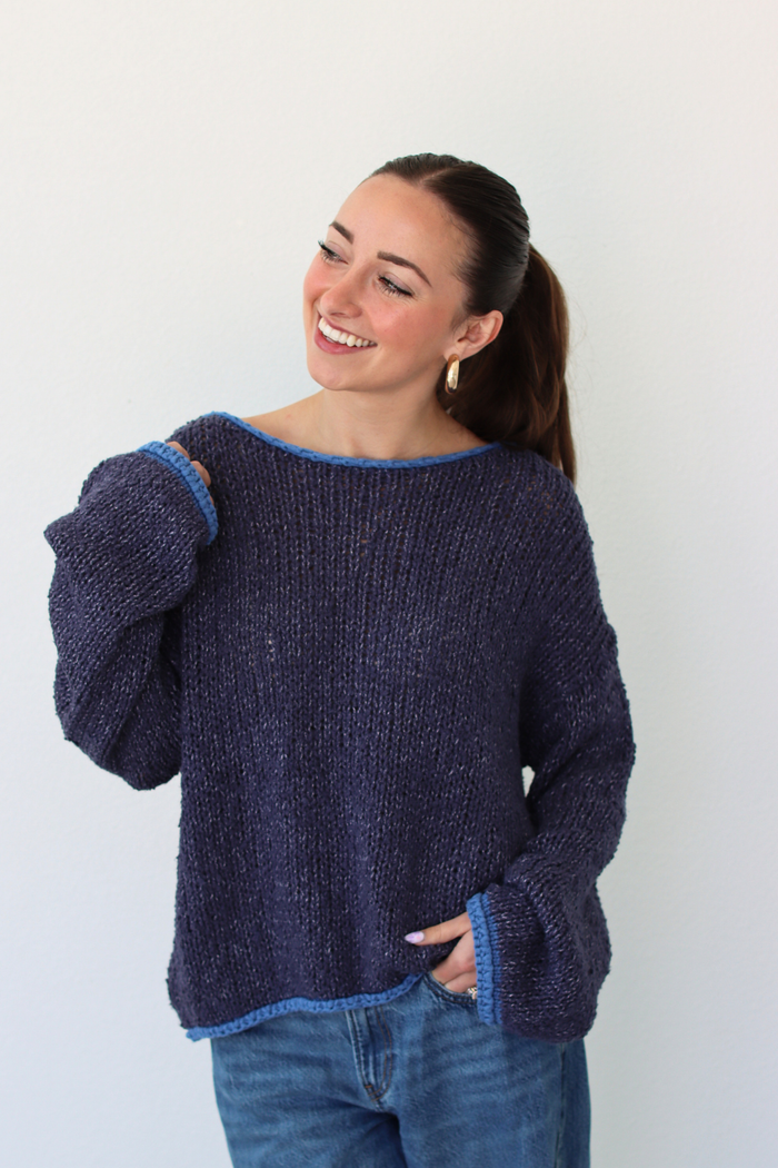 Woman wearing a dark blue sweater against a white background