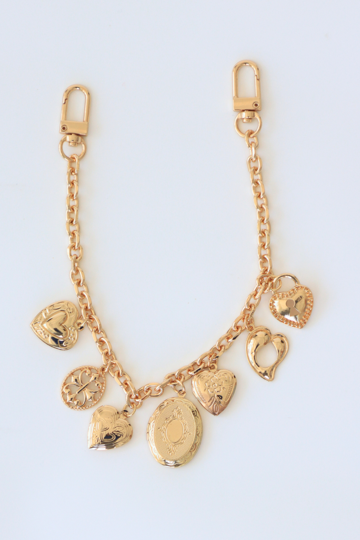 Gold charm bracelet on a light blue background