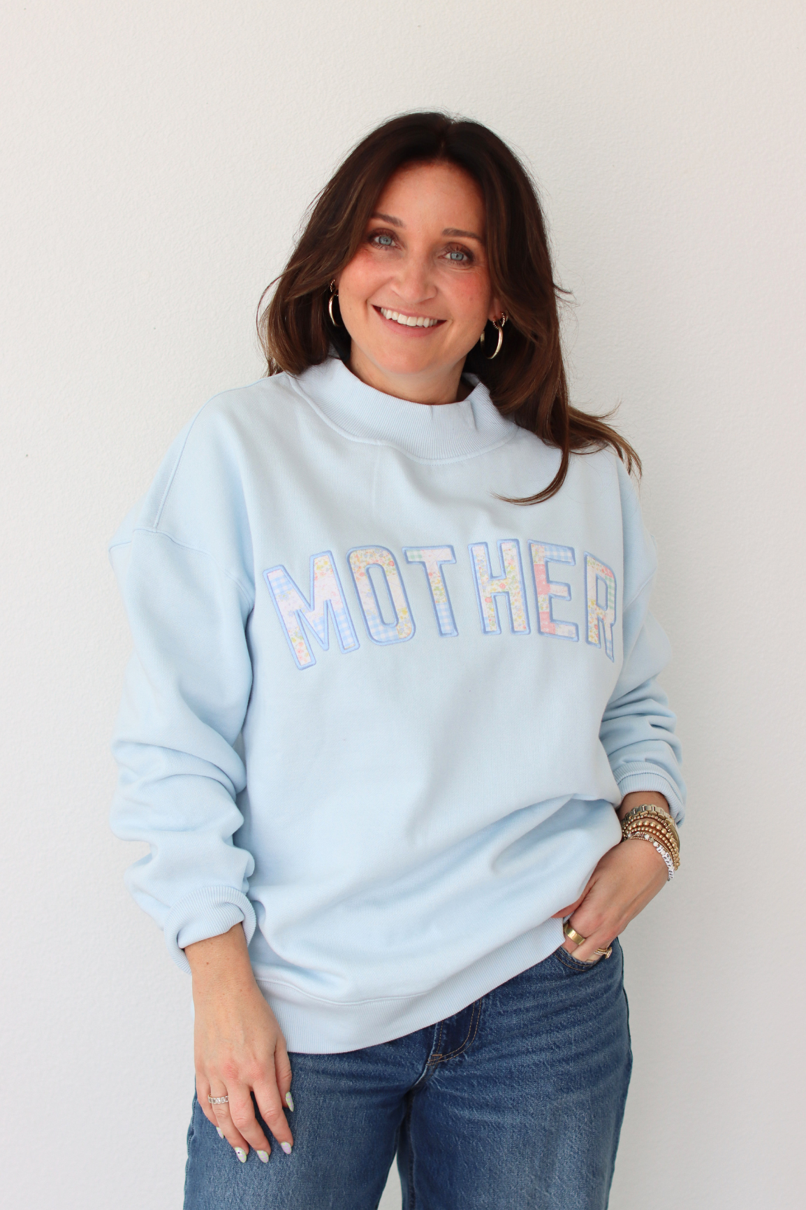 woman wearing light blue MOTHER sweatshirt