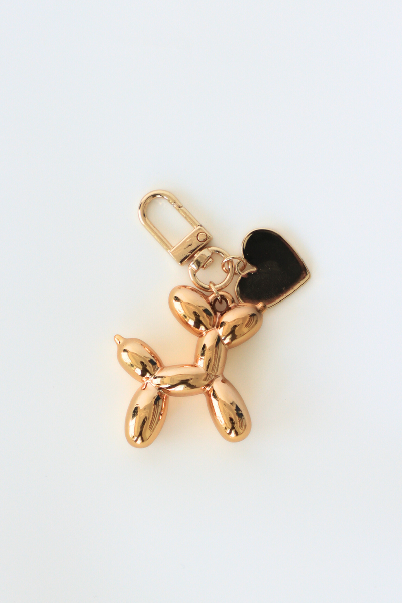 Gold balloon dog keychain on a white background