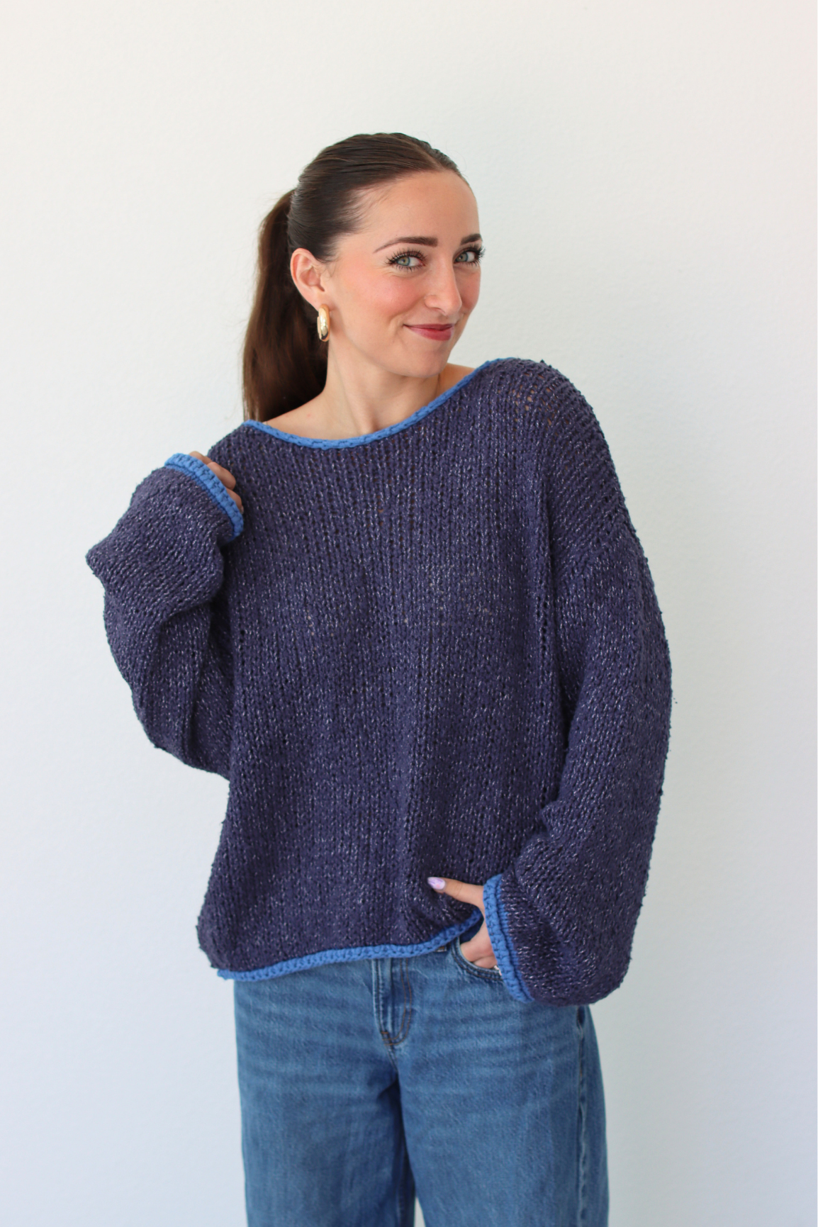 Woman wearing a dark blue sweater with a white background