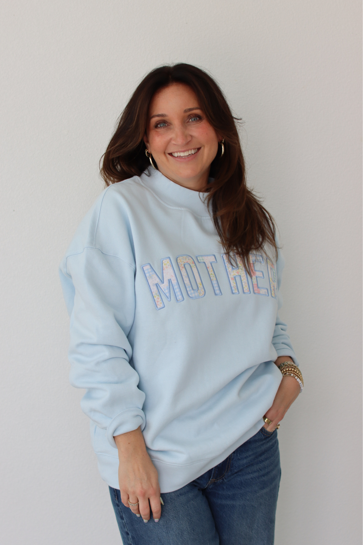 woman wearing light blue MOTHER sweatshirt