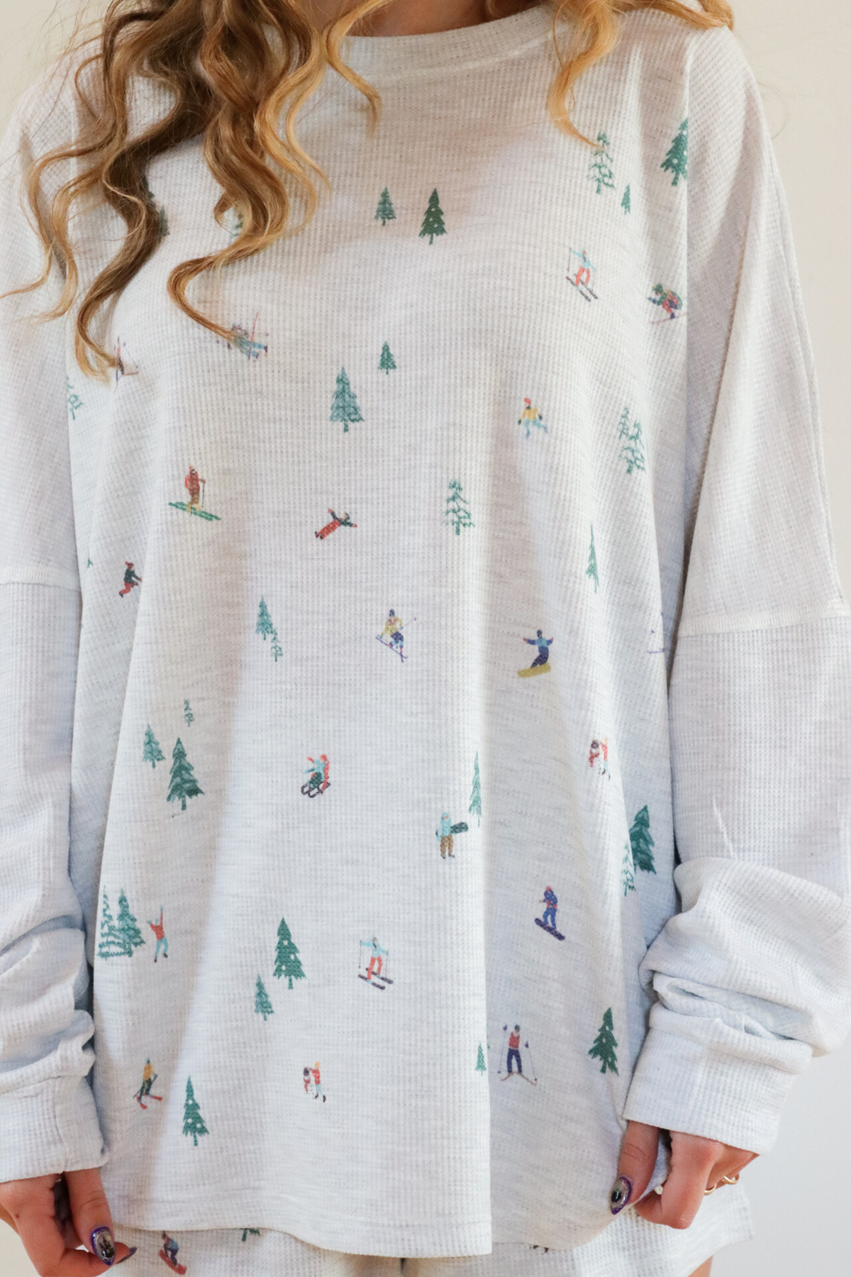 White long-sleeve shirt with skiing pattern worn by a person