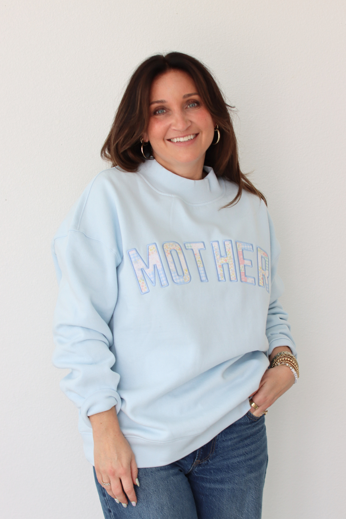 woman wearing light blue MOTHER sweatshirt