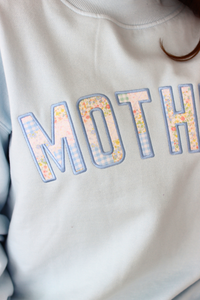 close up of gingham pattern on light blue MOTHER sweatshirt 