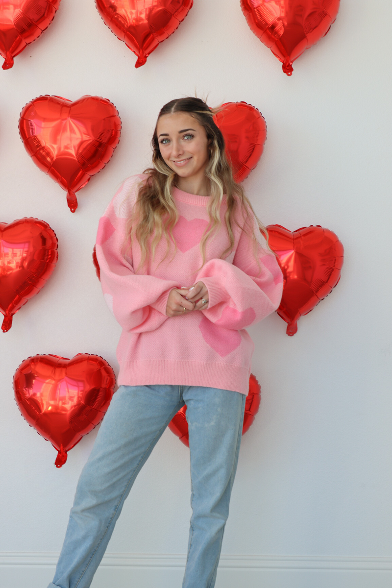 girl wearing pink heart knit sweater