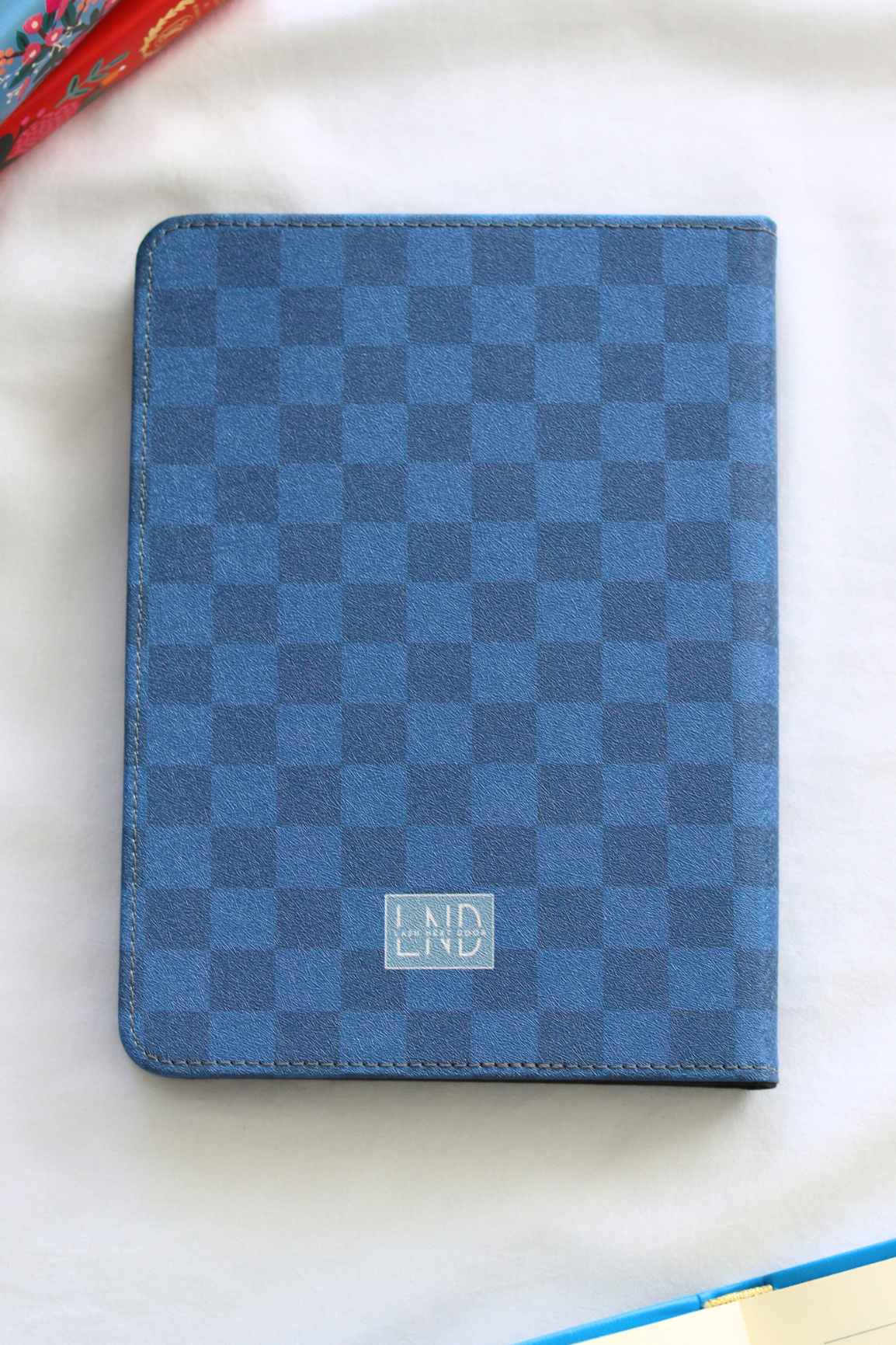 Blue checkered kindle with a brand logo on a white surface