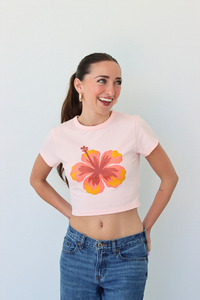 Woman wearing a pink t-shirt with a floral design against a white background