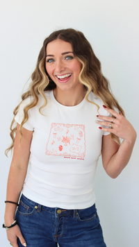 Woman wearing a white t-shirt with a graphic design, standing against a plain background