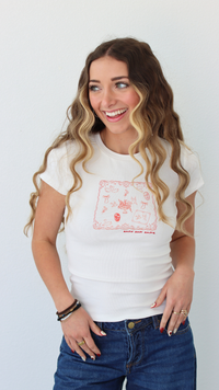 Woman wearing a white t-shirt with a graphic design, standing against a plain background