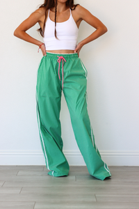 Person wearing green checkered pants with a white background
