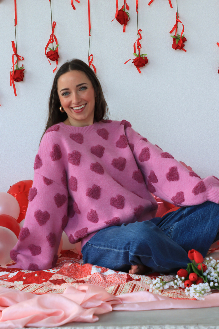 girl wearing pink heart sweater