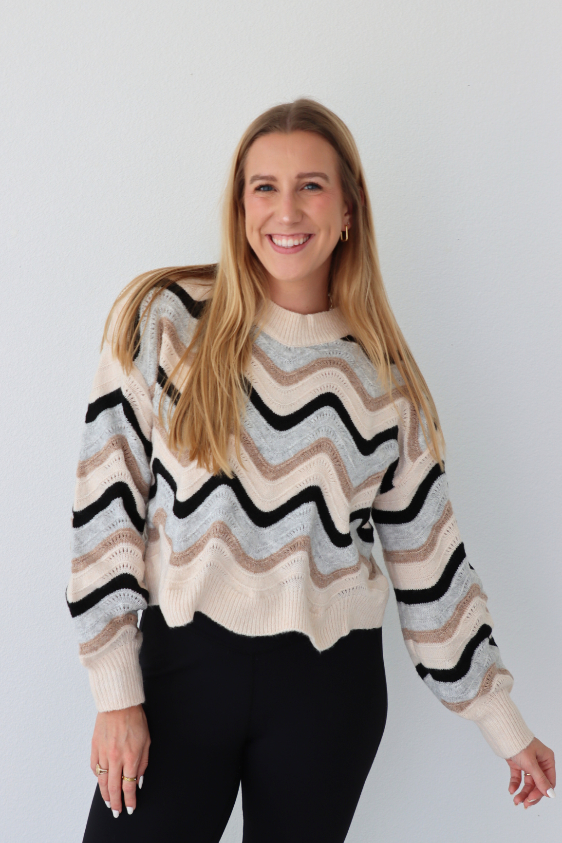 Woman wearing a striped sweater against a plain background