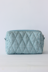A light blue and white gingham quilted cosmetic pouch with a top zipper closure, shown against a plain white background.