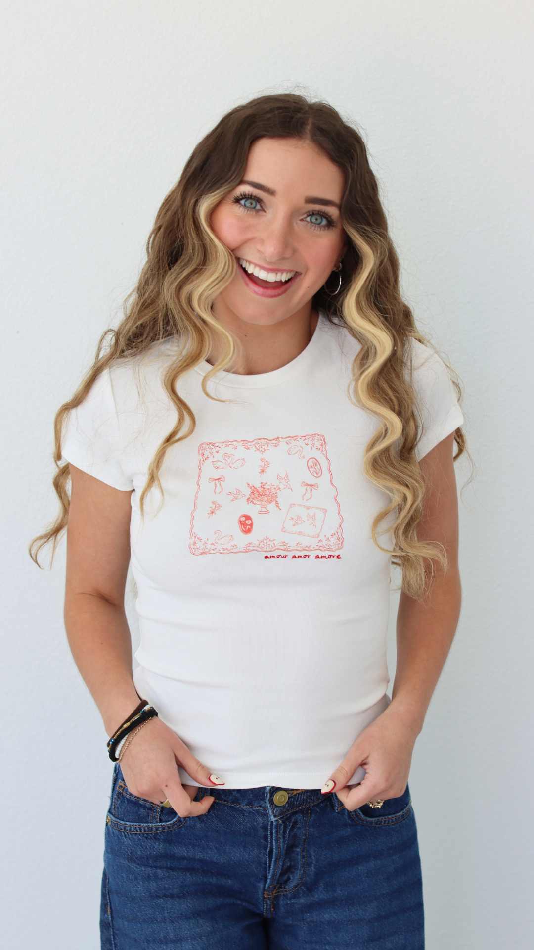 Woman wearing a white t-shirt with a graphic design, standing against a plain background