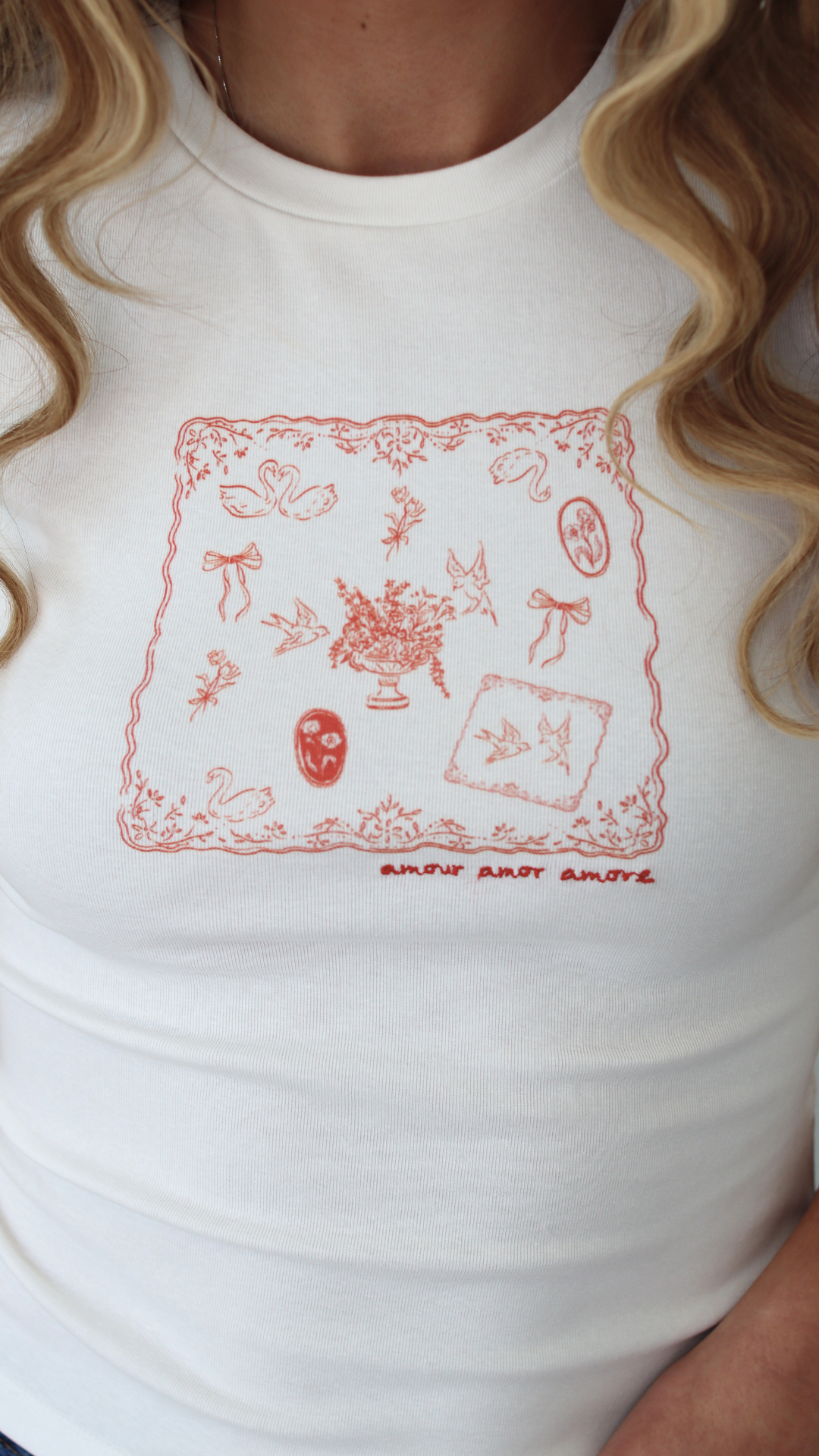 Woman wearing a white t-shirt with a graphic design saying amour amour amour 
