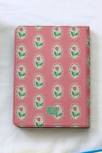 Pink kindle case with rose pattern and branding on a white background