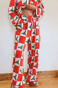 Red and white checkered outfit with green holly patterns on a plain background