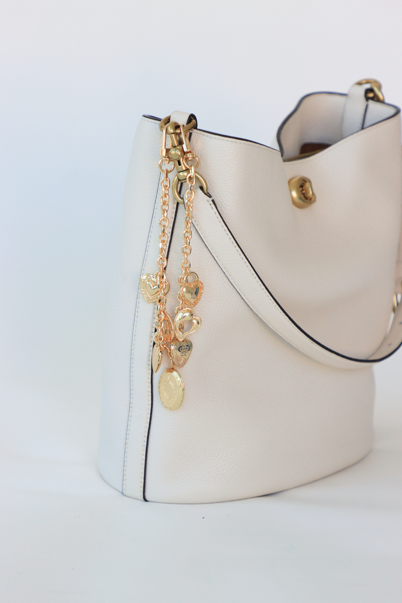 White handbag with gold chain detail on a white background