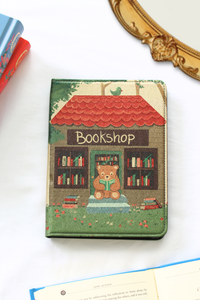 Kindle cover with a teddy bear and bookshop design on a white background