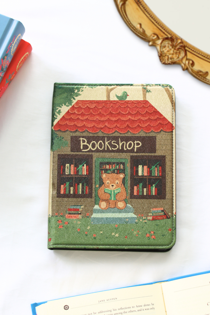 Kindle cover with a teddy bear and bookshop design on a white background