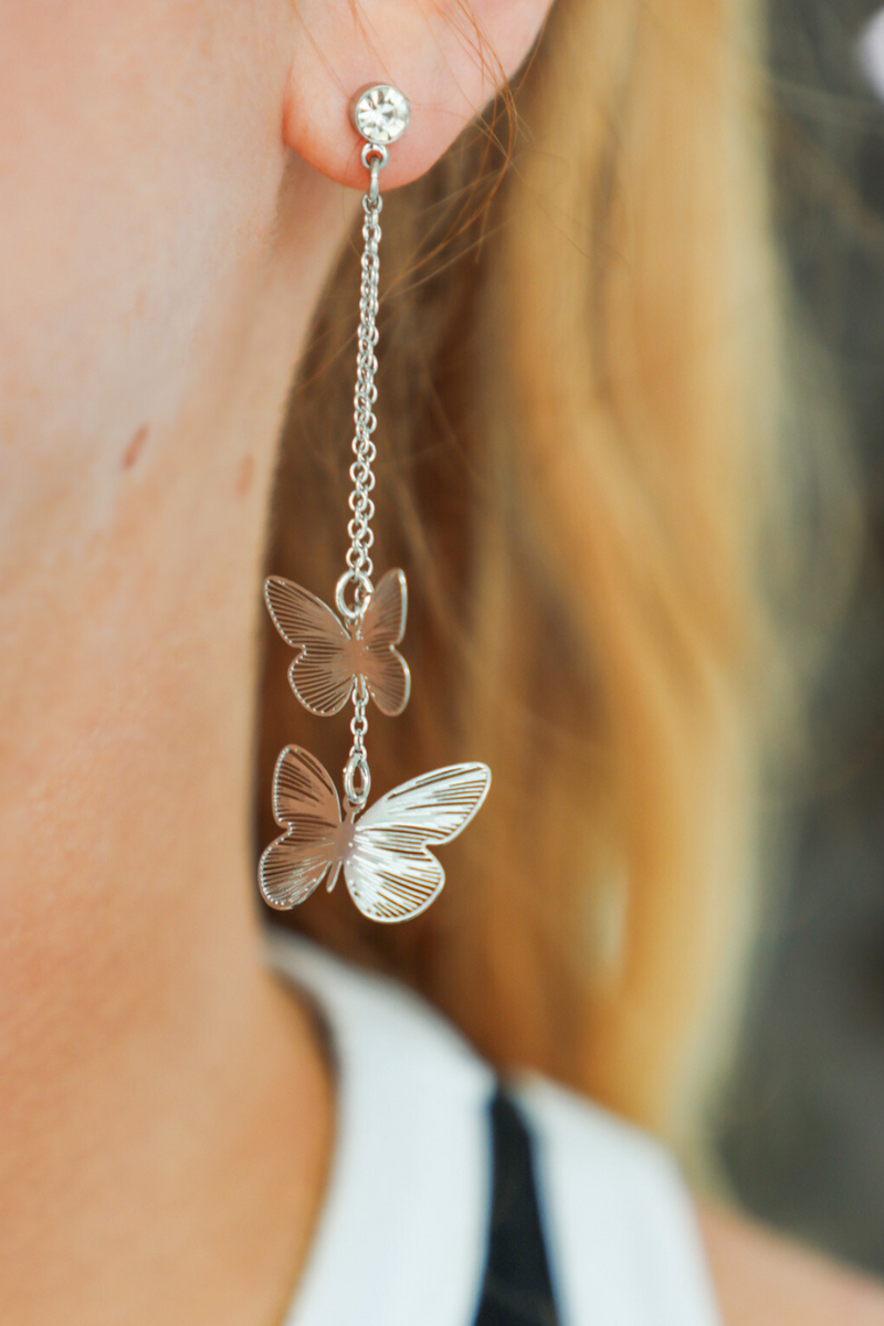 girl wearing silver butterfly earrings