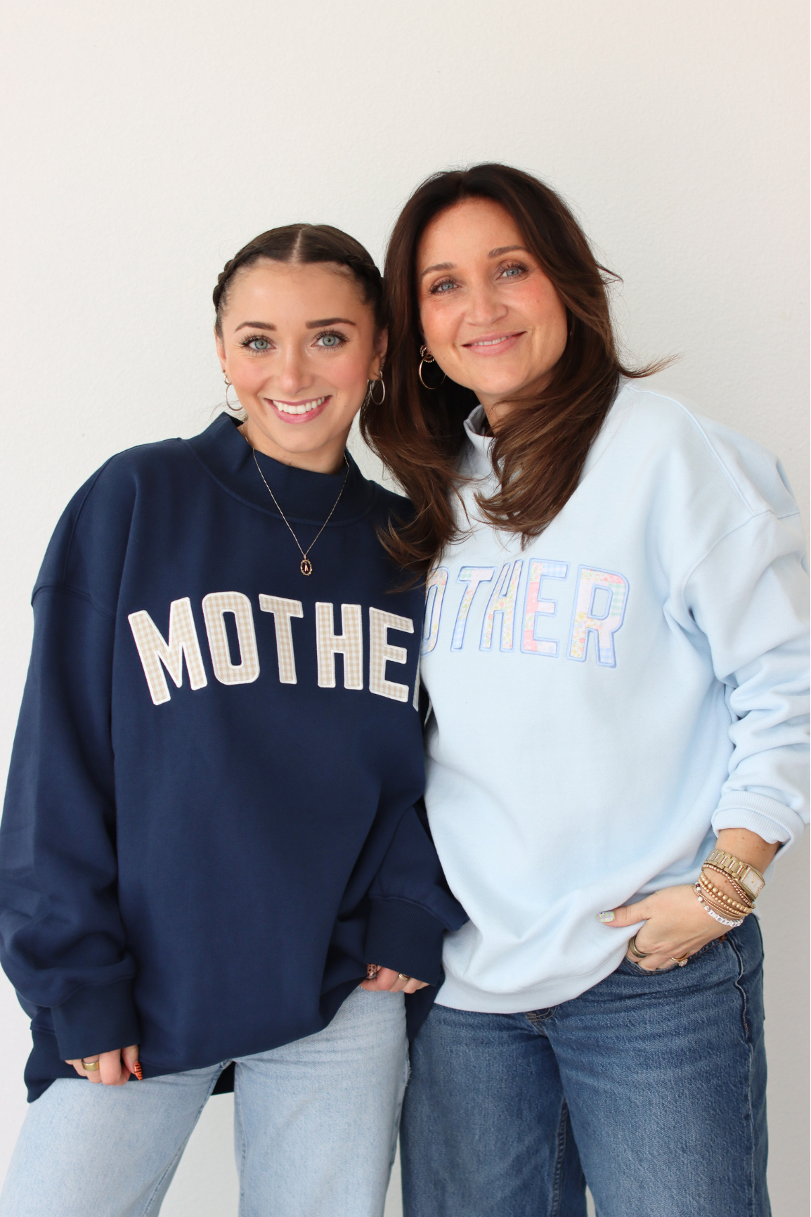 Two women wearing MOTHER sweatshirts