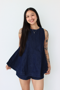 Woman wearing a navy blue outfit set against a white background