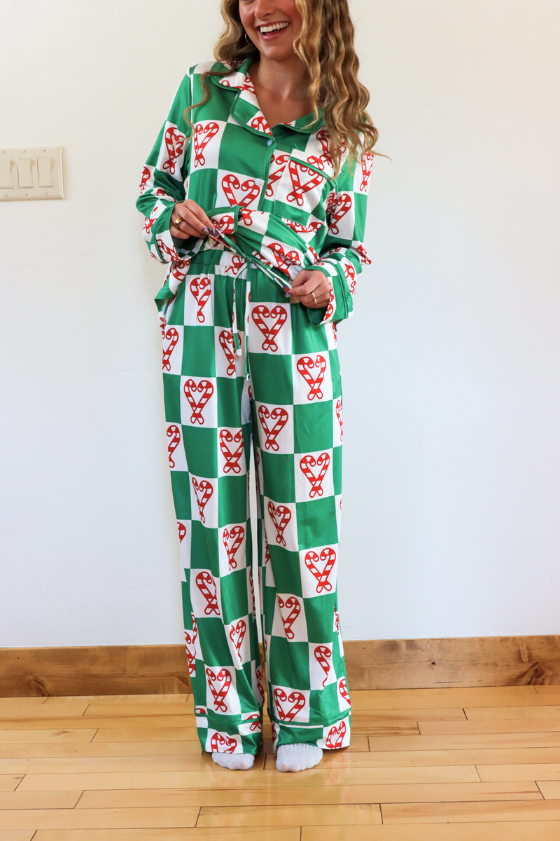 Person wearing a green and red patterned pajama set on a wooden floor.