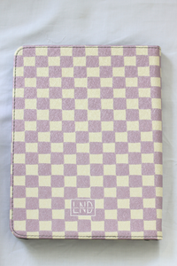 A nook case featuring a lavender and cream checkerboard pattern, with a small 'LND' logo near the bottom center, laid flat on a white fabric background.