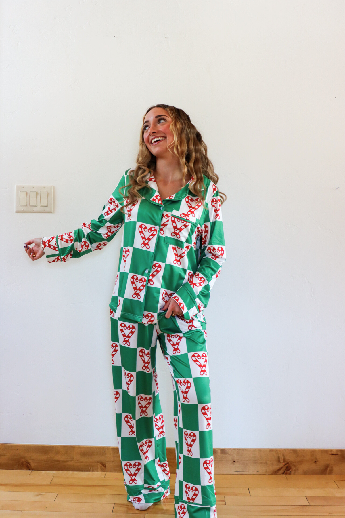Woman wearing a green and red checkered onesie with animal patterns in a room.
